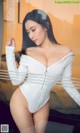 a woman in a white bodysuit posing for the camera