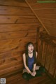 A woman sitting on the stairs of a wooden cabin.