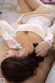 A woman laying on top of a bed wearing white gloves.