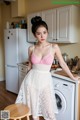 A woman standing in a kitchen next to a washing machine.