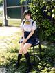 A woman sitting on a chair in a park.