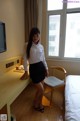 A woman standing in front of a window in a hotel room.